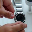 Team member examining a wearable device under a magnifying glass